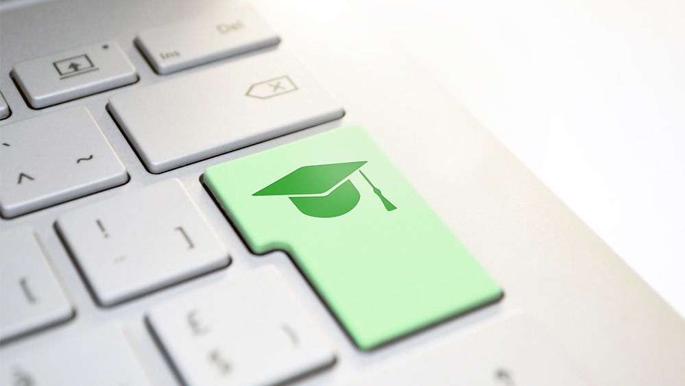 Section of a keyboard with green Enter key and diploma hat